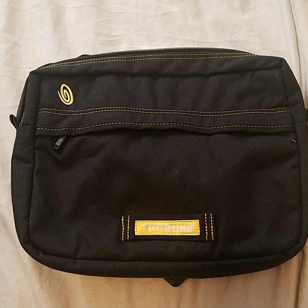 Black Timbuk2 waistpack with yellow stitching.